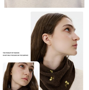 Detail of wool knit scarf with delicate yellow flower embroidery in dark brown