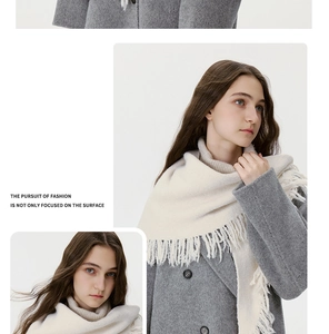 Detail of soft cream knitted scarf with fringe edge and grey wool cardigan button