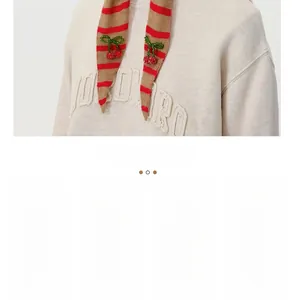 Detail of striped knit scarf with decorative 3D cherry beads and wool texture