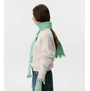 Close-up of soft mint green mohair knit scarf and gloves set with fringe detail