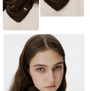Detailed close-up of dark brown knitted wool neck warmer with yellow floral embroidery