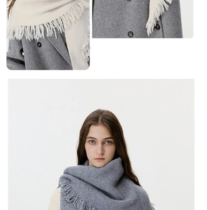 Detail of wool knit tassel scarf texture and styling in dark grey and beige colors