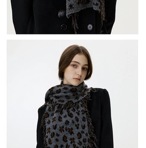 Macro detail of leopard print knit texture and long fringe tassels on a winter shawl