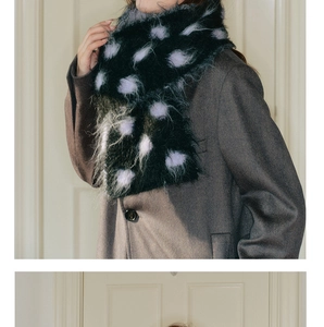 Close-up of black fluffy wool scarf with purple polka dots on a grey coat