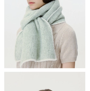 Detailed texture of mint green knit scarf featuring vertical ribbed patterns and soft wool