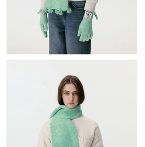 Close-up of mint green wool blend knitted scarf and gloves with heart label detail