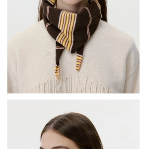 Detail of striped knit scarf in brown and yellow with soft wool blend texture
