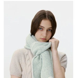 Detail showing mint green knit scarf texture with soft wool blend and vertical stripes