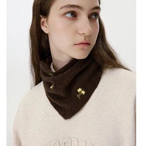 Detailed knit texture of dark brown neck warmer with yellow flower embroidery