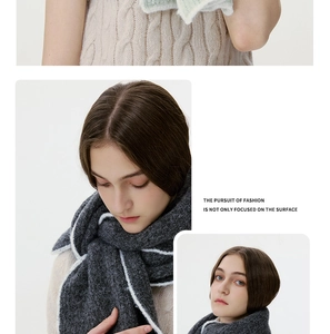 Detail of dark grey wool blend knit scarf with contrast white edges and soft fuzzy texture