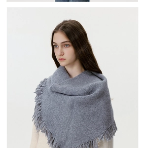 Detailed view of the soft knit texture and long tassels on this warm grey wool scarf