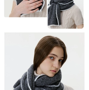 Detail of dark grey wool blend knit scarf featuring contrasting white striped edge detail