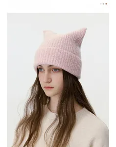 Detailed close-up of pink knit cat ear hat with thick ribbed texture and wool blend fabric
