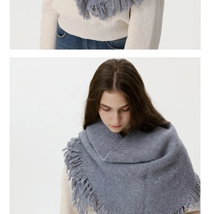 Close-up of deep grey wool knit scarf featuring rich fringe details and warm texture