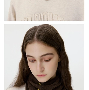 Detail of wool knit scarf with flower embroidery and beige embossed letter sweatshirt