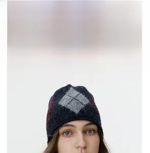 Detail of argyle knit beanie featuring navy and grey diamond patterns with warm textures