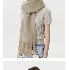 Close-up of beige wool blend scarf featuring soft plush texture and long fringe tassels
