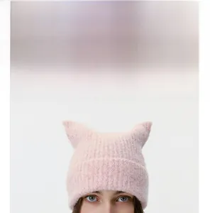 Detail of pink knitted cat ear hat with soft fuzzy wool texture and knit patterns