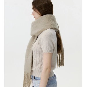 Close-up of thick beige wool blend scarf with fringe details for warm winter styling