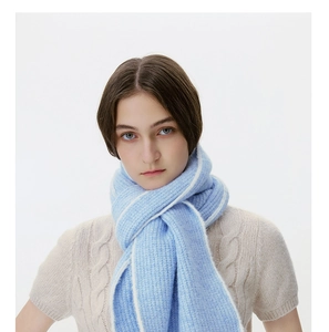 Close-up of light blue wool blend scarf featuring white contrast edge and soft texture