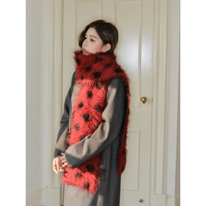 Thick wool scarf with red and black polka dot pattern worn by model in winter style