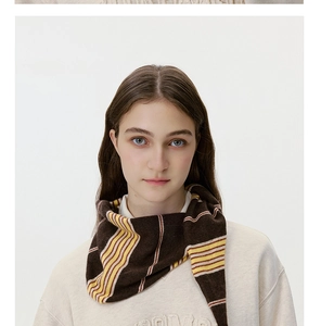 Detailed close-up showing the striped texture of this brown and yellow knitted scarf