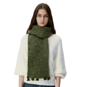 Deep green wool blend knit scarf with fringe trim worn on a white sweater
