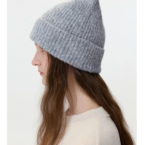 Close-up of light grey wool blend knit beanie showing thick vertical ribbed texture