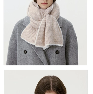 Close-up of beige knit wool blend scarf with chunky texture on grey wool coat