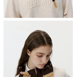 Detail of striped knit neckerchief with Morumuru embroidery on white sweatshirt