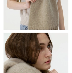 Close-up detail of soft oatmeal wool blend scarf with textured tassels and knit finish