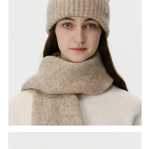 Close-up of oatmeal knit hat and scarf set with premium wool texture and gold logo plate