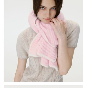Detail of pink knitted wool scarf with white contrast edges and soft ribbed texture