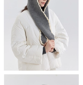 Detail of grey knitted hooded scarf with white scalloped edges and thick yarn texture