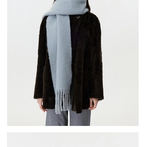 Detail of light blue wool blend scarf with soft fringe tassels and plush winter texture