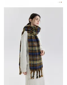 Detail of soft chunky knit scarf with mustard yellow plaid pattern and thick fringe