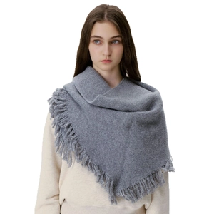 Soft wool-blend grey knit triangle scarf with elegant tassel trim worn as a warm shawl