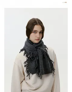 Detail of dark grey wool blend knitted scarf featuring delicate fringe edge tassels