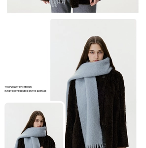 Detail of light blue wool blend scarf with fringe tassels and soft plush knit texture