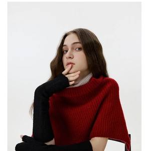Close-up of red chunky knit shawl and black long fingerless arm warmers on model