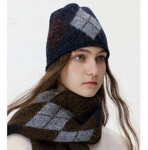 Detail of winter thick knit set with argyle patterned navy beanie and matching scarf