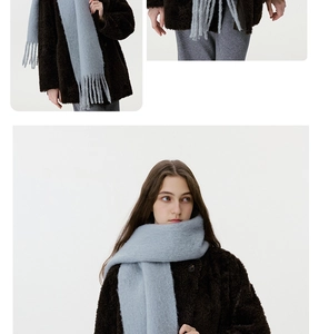 Detailed close-up of light blue wool blend scarf showing thick fringe and soft texture