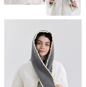Detail of grey knitted hood with cream scalloped edges and cozy warm wool texture