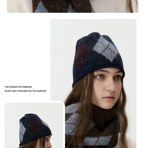 Detail view of navy blue argyle knit beanie and matching scarf set in soft wool blend