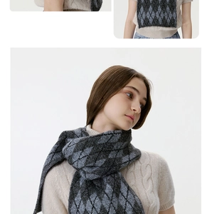 Detail of grey and blue diamond knit scarf texture on model wearing beige sweater