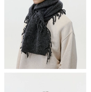 Close-up of charcoal grey wool blend knit scarf showing soft fringe details