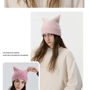 Detail of wool blend knitted cat ear beanie showing fuzzy texture and soft pink color