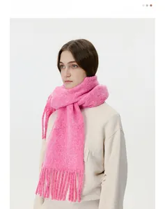 Close-up of bright pink knitted scarf featuring long tassels and soft mohair texture