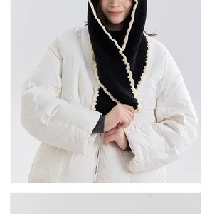 Close-up of black knitted hood scarf with cream scalloped edges and thick warm texture