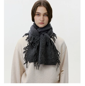 Detailed texture of thick dark grey wool blend knitted scarf with elegant long tassels